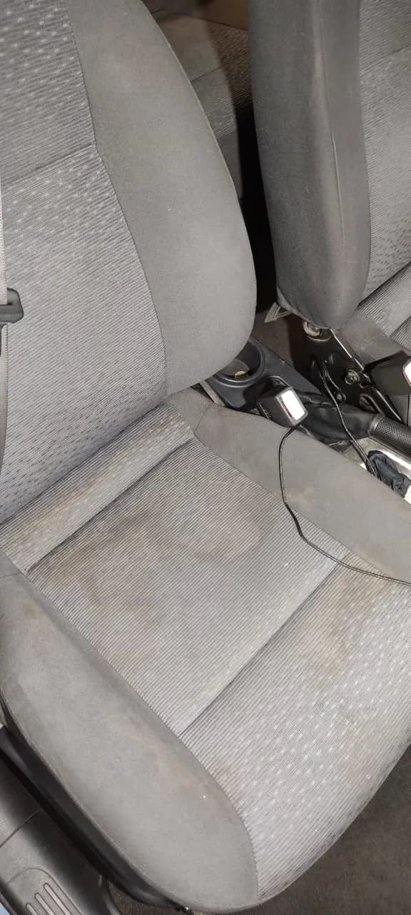 Asientos del auto con polvo y suciedad acumulada antes del servicio
